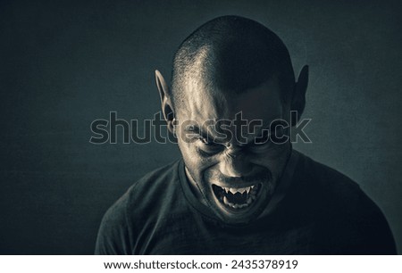 Monster, man and face with horror in studio for fantasy, demon and angry vampire with fangs, scary and terror. Werewolf, devil and creepy creature with shouting, rage and surreal on black background Royalty-Free Stock Photo #2435378919