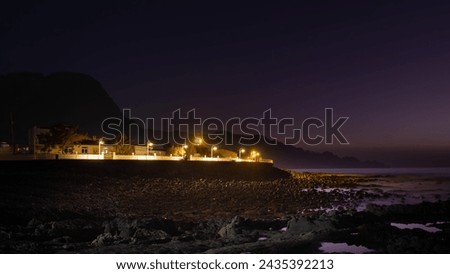 Buildings and waterfront of Puerto de las Nieves near Agaete in Gran Canaria, Spain. Long exposure nightime image Royalty-Free Stock Photo #2435392213