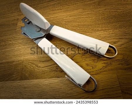Can opener on a wooden worktop Royalty-Free Stock Photo #2435398553