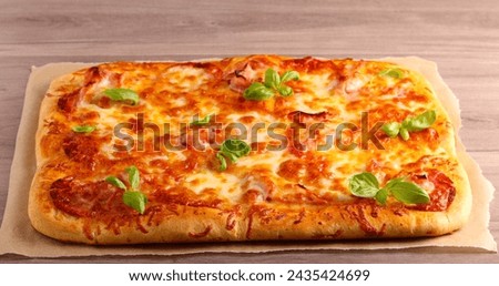 Fresh homemade rectangle pizza on table Royalty-Free Stock Photo #2435424699