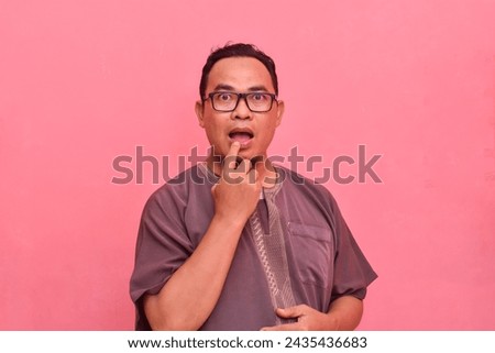 Photo of screaming young man with glasses over red background