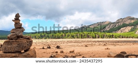 Near Porto-Vecchio, in the heart of Alta Rocca, Lake U Spidali is nestled between road and mountains. Due to the drought, the water level has dropped, revealing tree stumps cut before impoundment Royalty-Free Stock Photo #2435437295
