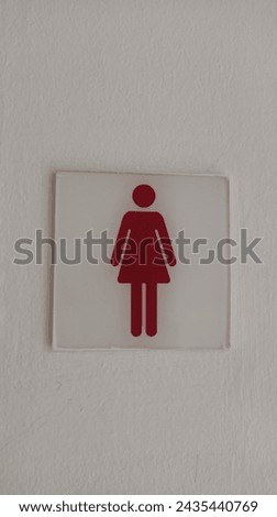 Women's restroom sign  mounted on a white wall.