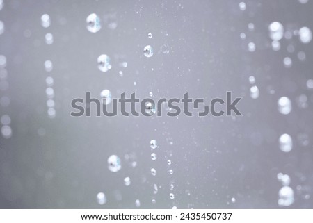 Delicate small raindrops seen on the glass close up, wet glass, autumn rainy nostalgic day, rainy weather, water drops on the glass, refreshed smooth macro pattern drop background closeup
