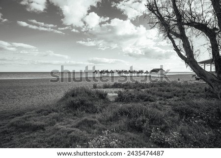 The photograph captures the expansive beauty of a beachscape in striking black and white, taken with a wide-angle lens