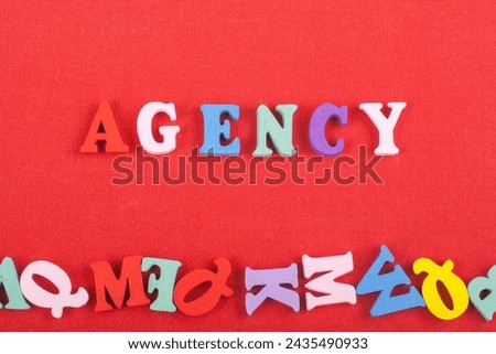 AGENCY word on red background composed from colorful abc alphabet block wooden letters, copy space for ad text. Learning english concept