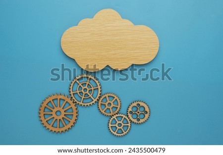 Flatlay picture of cloud with gear on blue background. Cloud technology concept.