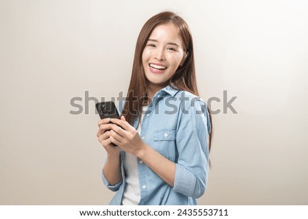 Happy asian young woman using mobile smart phone, read good news online, laugh excited getting offer, great positive surprise, celebrate success on smartphone. Smile girl isolated on white background.