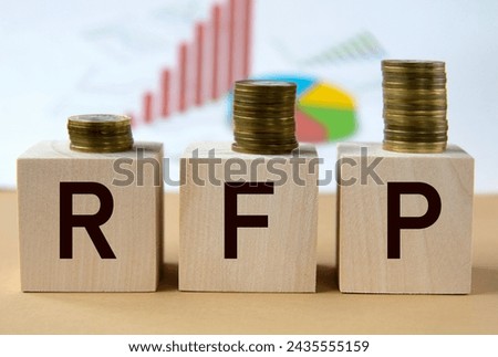 RFP - abbreviation on wooden balls on a background of coins and graphics. Business concept