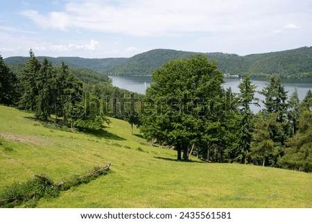 Landscape with a view of Lake Edersee with trees, blue sky and clouds, in Hesse, Germany