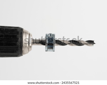 selected focus of Woodworking steel drill bit in Electric drill  with depth collars attached  isolated on a white background