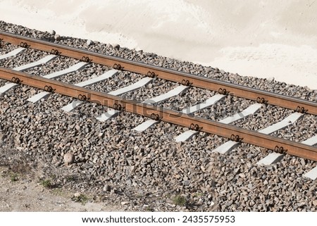 Railroad background. Railway perspective. Train track landscape. Old railroad wooden tie. Track ballast gravel made of crushed stone.