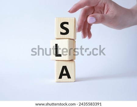 SLA - Service Level Agreement. Wooden cubes with word SLA. Businessman hand. Beautiful white background. Business and Service Level Agreement concept. Copy space.