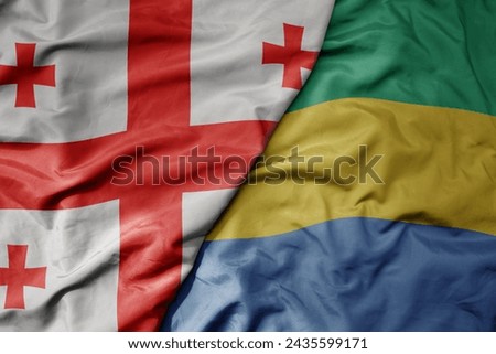big waving national colorful flag of gabon and national flag of georgia . macro