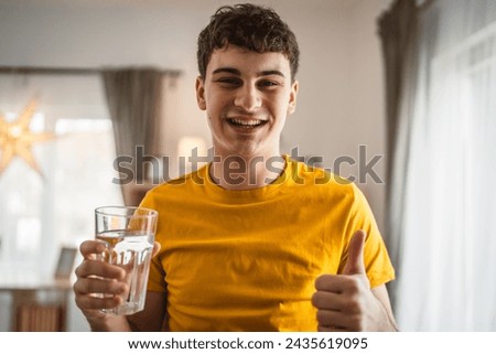man young caucasian male hold glass of water at home