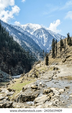 Mountains covered with snow having huts, river side market