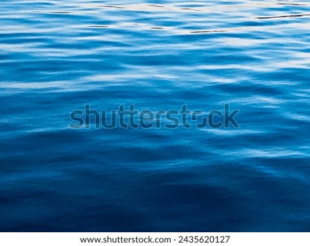 Blue water backdrop with light reflecting on subtle ripples and movement.