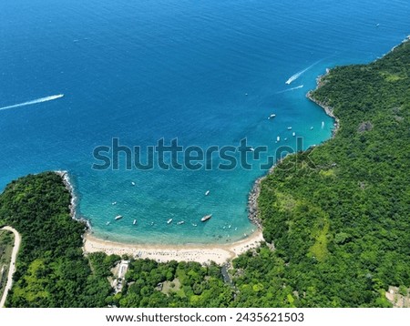 aerial photo taken with a drone of a blue water beach with clear sand and forest
