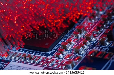 Macro photograph of a printed circuit board with a processor and optical fibers illuminating the board Royalty-Free Stock Photo #2435635413
