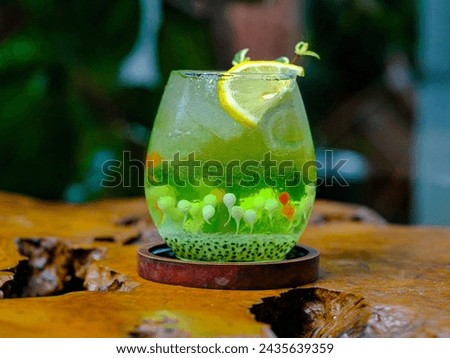 Fresh and cold drink mixed with green basil seed soda syrup and garnished with a lemon slice Royalty-Free Stock Photo #2435639359