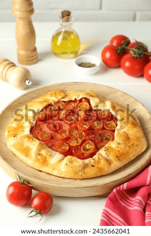 Tasty tomato galette (Caprese galette) on white wooden table, closeup