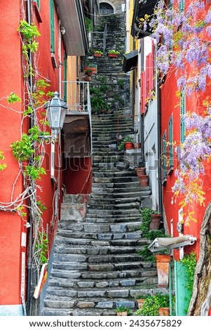 Varenna, Province Lecco,  Lombardy, Italy, Europe - narrow colorful street in historic part of the city, Lake Como shore, April Royalty-Free Stock Photo #2435675829