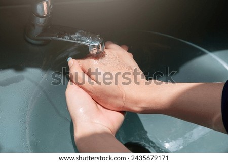 Wash your hands using hand sanitizer to kill germs that you might accidentally touch, such as the COVID-19 virus, before working or eating or doing other activities. Royalty-Free Stock Photo #2435679171