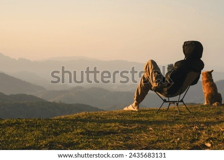 nature traveling with solo man play with dog and see sunrise with layer of mountain