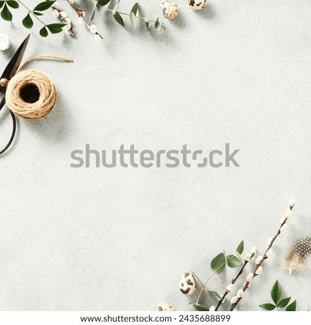 Easter background with Easter eggs, feathers and spring flowers. Top view with copy space. Border, mock up square composition Royalty-Free Stock Photo #2435688899