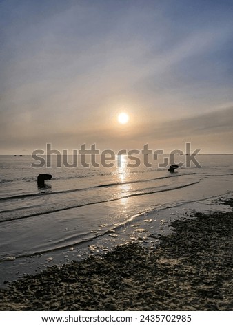 A picture of the sun setting in the cloudy sky in the West Sea