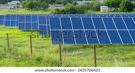 Landscape picture of a solar plant that is located inside a valley surrounded by mountain  background of a blue cloudy sky. Solar power plant. Blue solar panels. An alternative source of electricity.