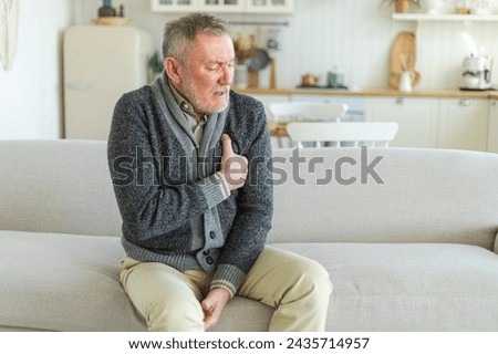 Pain on heart, heart attack. Unhappy middle aged senior man suffering from chest pain heart attack problems with health at home. Mature old senior grandfather touching chest experiencing infarction Royalty-Free Stock Photo #2435714957