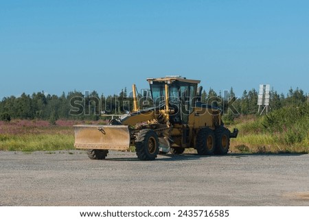 grader Heavy equipment at worksite, Grader Loader in action on highway, Construction Machinery on a Renovation Project in Heavy Industry. Royalty-Free Stock Photo #2435716585