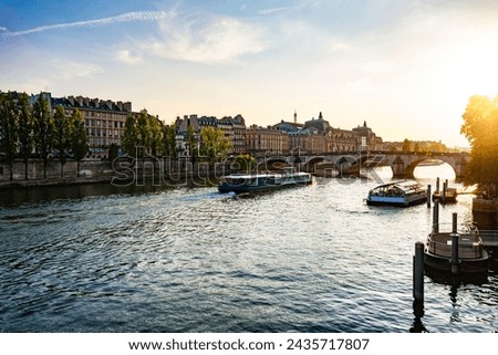 Beautiful Paris background at sunset showing Pont Royal Bridge, several cruise ships, and Orsay Museum at the background