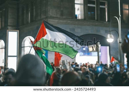 Pro - palestinian protests in Berlin. Flags of palestine waving between the people supporting palestine over israeli invasion of gaza.. Pro palestinian protests at night in european city Royalty-Free Stock Photo #2435724493