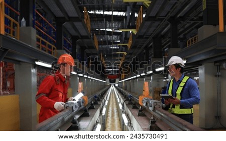 The railway chief engineer and maintenance engineer collaborate on maintaining the electric train tracks at the Sky train garage. Royalty-Free Stock Photo #2435730491