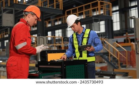 The railway chief engineer and maintenance engineer collaborate on maintaining the electric train tracks at the Sky train garage. Royalty-Free Stock Photo #2435730493