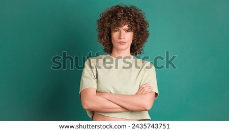 Disagreeing young woman shaking head with twisted mouth on green background Royalty-Free Stock Photo #2435743751