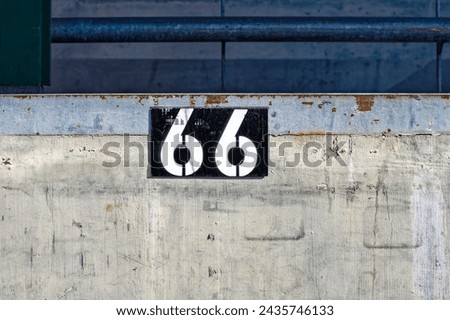 White number 66 against black background on concrete wall at Swiss City of Zürich on a sunny winter morning. Photo taken March 9th, 2024, Zurich, Switzerland. Royalty-Free Stock Photo #2435746133