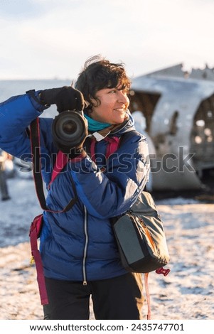 Portrait of adventurous photographer woman in winter in Iceland on the plane by Solheimasandur