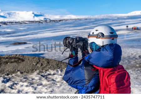 Adventurous female photographer in winter in Iceland photographing at the Vatnajokull Glacier