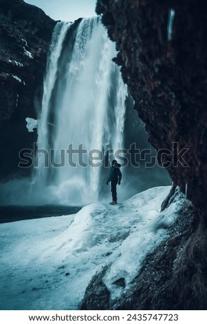 Photographer woman in winter in Iceland visiting Skogafoss waterfall