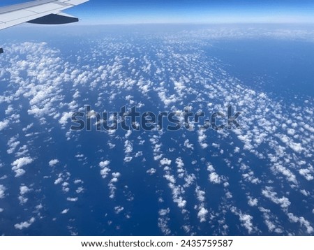 Exterior photo visual view of above the sky with the wing engine of a filgth flying over the clouds through the plane round window toward destination for travel in the air using this transportation