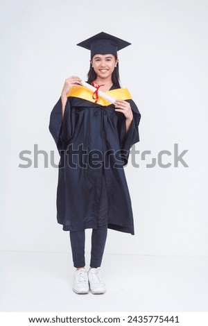 Full body photo of a happy female graduate of bachelor of science holding her diploma. Beaming with optimism. Isolated on a white background.