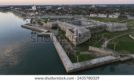 Historic Castillo de San Marcos in St. Augustine, Florida at sunrise with a background of downtown St. Augustine Royalty-Free Stock Photo #2435780329