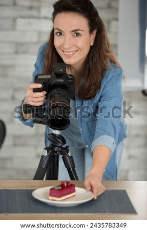 young woman with professional camera taking food photo in studio