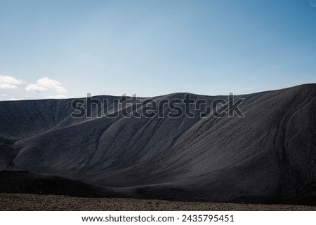 Black volcanic sand surface on the crater rim, close up aerial view. Texture, background, abstract concepts.