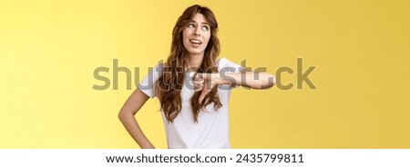 Blah blah boring. Unimpressed apathetic snobbish attractive curly-haired girl look away express scorn disdain show thumb down frowning sharing negative judgement bad opinion yellow background. Royalty-Free Stock Photo #2435799811