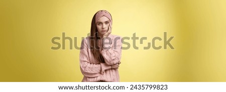 How boring. Indifferent upset gloomy girl missing party feeling bored leaning on palm reluctant, sad looking careless at camera visiting uninteresting lecture, suffering boredom over yellow wall. Royalty-Free Stock Photo #2435799823