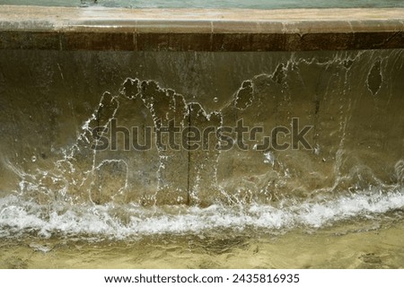 A sheet of water flowing out of a fountain, frozen by high shutter speed. 